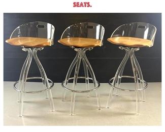 Lot 884 Set 3 Modernist Lucite Swivel Bar Stools. Lucite stem legs with chrome foot rests. Wood Seats. 