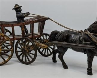 Cast iron horse-driven cart with rider. 