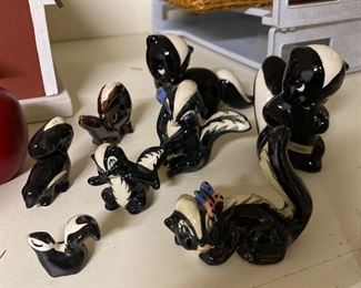 Collection of vintage ceramic skunk figurines.