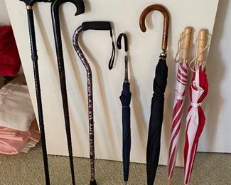 Selection of walking canes and umbrellas.