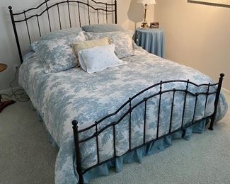 Queen-size bed with metal head- and footboards, mattress and box spring.