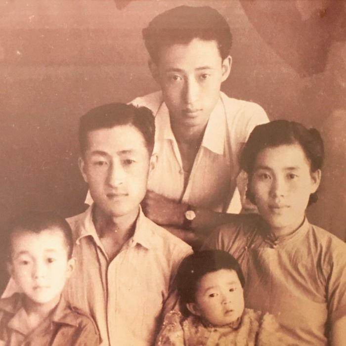 Dr Ge Ge (pronounced Guh Gee) sits on his dads knee (L) as he looks pensively into the camera. Maybe aware of the journey he was about to embark upon. His little sister Mary, his heart, sits on his moms lap. 