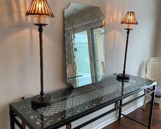 Designer metal and glass-topped console/sideboard table in excellent condition, tall buffet lamps in oil-rubbed bronze, and mirror with floral etching on the boarder.