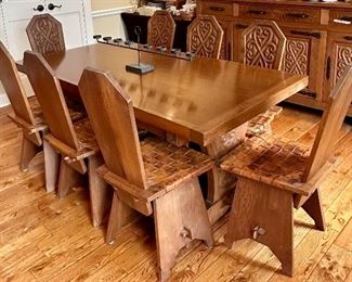 This dining set was purchased in the early 1950s by our homeowner's in-laws. It was hand carved in Brittany, France by master carpenters. Truly unique and a show-stopper! The seats are woven in leather!  