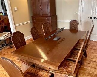 This dining set was purchased in the early 1950s by our homeowner's in-laws. It was hand carved in Brittany, France by master carpenters. Truly unique and a show-stopper! The seats are woven in leather!  