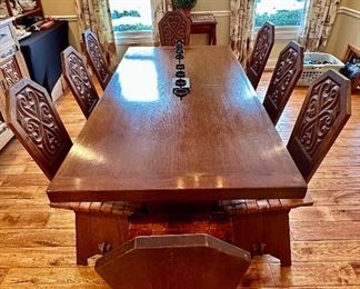 This dining set was purchased in the early 1950s by our homeowner's in-laws. It was hand carved in Brittany, France by master carpenters. Truly unique and a show-stopper! The seats are woven in leather!  