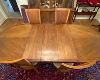 Pristine oblong dining table with two leaves and table pads.