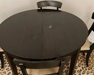 Pottery Barn Ebony Extension Table on Casters. Shown with Set of 4 Pottery Barn Dining Chairs.  Table Measures 47" D and Extends to 84" L x 47" W x 29" H with Two 18" Leaves. Photo 2 of 2. 
