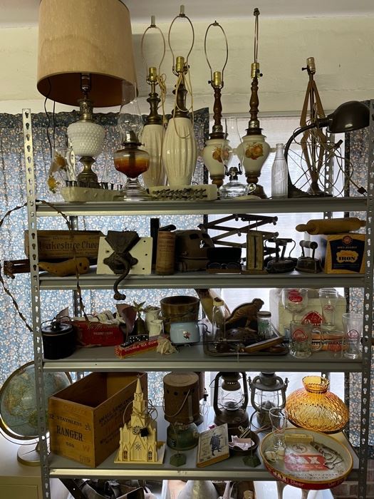 MCM lamps, oil lamps, Pearl Beer glasses, lanterns, general store grinder, wooden cheese box, Victorian sad irons, enamel potty, wood ammo crate, telephone batteries, postal scale, Jax beer tray, school globe, barbed wire, antique bottles, plastic Christmas decor from the early 60s . . . keep looking!