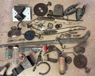 Griswold, ox yoke collars, Curity baby bottle, pocket knives, calf weaners, Victorian irons, cow bells from the '20s & '30s, egg beater, scale weights, general store grinder