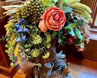 Floral arrangement in beautiful woodsman vessel.