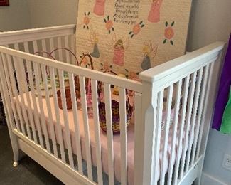 White baby crib and handmade quilt