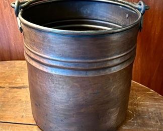 Large bronze metal bucket with handle.
