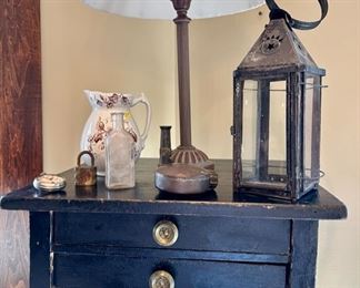 Antique Hepplewhite black table with 2 drawers. Brown transfer ware pitcher, antique Witches Hat tin lantern - SOLD, copper yard sprinkler and brass hose nozzle.