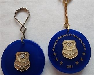GBI badge pin prototype keychain and final keychain.