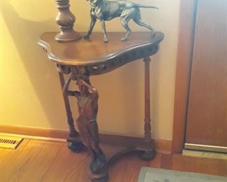 Three legged table with carved figural features