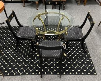 Hollywood Regency Round glass top solid brass table with swans heads, set of 4 black chairs with gold medallions and new upholstered seats in gold and black.