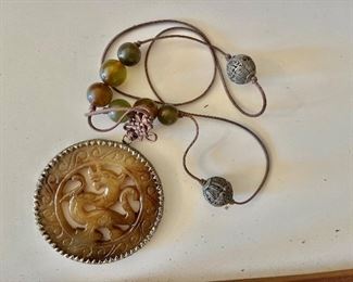 Carved dragon pendant on cord 