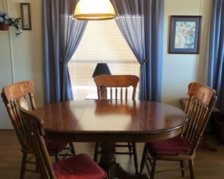Beautiful oak oval dining room table with one leaf.  Four pressed back chairs.  So nice.