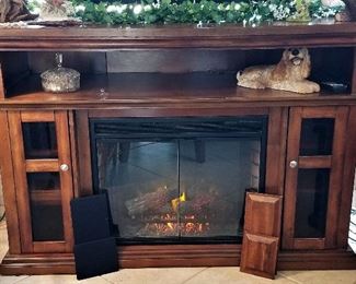 Electric fireplace with side doors that can be changed to solid or fabric speaker inserts.
