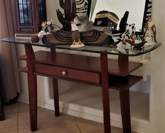 Wood and glass console with drawer has matching end tables and coffee table.
