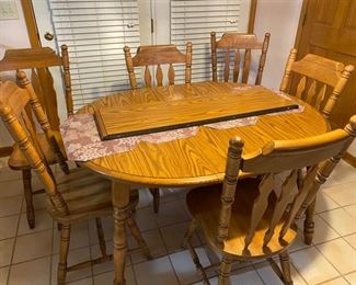 Oak Kitchen table with 2 leaves and 6 chairs.