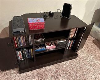 TV stand w/ shelves and doors. CD movies, HULU unit & a Belkin multi surge protector plug-ins.