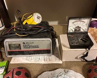 Schmacher starter charger and a Micronta 22-211A OHMS/VOTE meter.