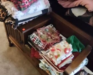 Linens piled atop a vintage/antique telephone table or 'gossip bench'