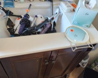 bathroom supplies, including a large selection of curling irons