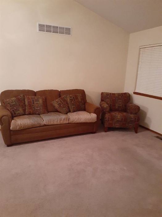 Leather and upholstered couch with upholstered chair.