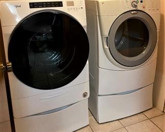 LIKE NEW WHIRLPOOL FRONT LOADER WASHER AND DRYER WITH PEDESTALS.