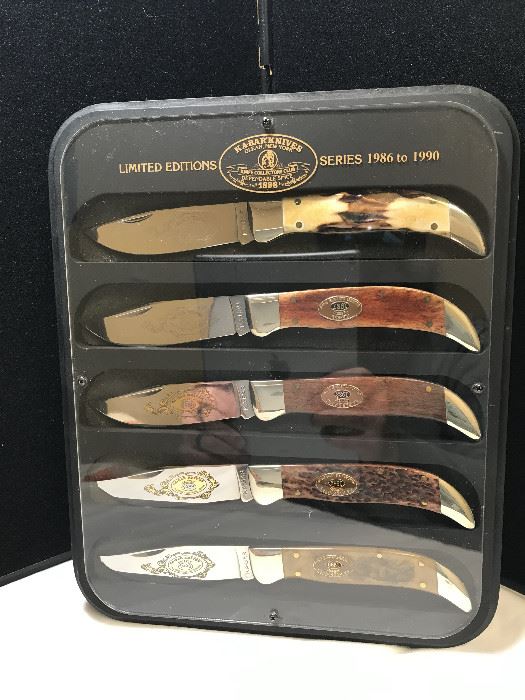 Lot 3 KA-Bar 5 Knife Series For Collectors Club '86-'90
Limited edition series for KA-Bar Collectors Club years 1981 - 1985 bolsters are nickel silver, the handles on the knives are '86 - Stag, '87 Rosewood, '88 Dark Hardwood, '89 Jigged Brown Bone, '90 Clear acrylic with a grizzly bear scene, Display Case.  
