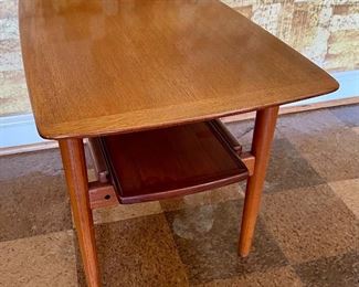 The bottom tier of the table is a tray that extends.