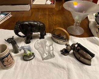 A herd of elephants are stampeding in Fort!! on top you got the cast-iron elephant, left side you’ve an elephant Jigger, next year, the Peint Main Limoges elephant, trinket box, in the middle, you have the Mats Jonasson elephant, lead crystal, and the right side you have the magnetic bejeweled elephant trinket box. On the far left, you have a small Western Germany Stein and on the right you have two small sad irons.