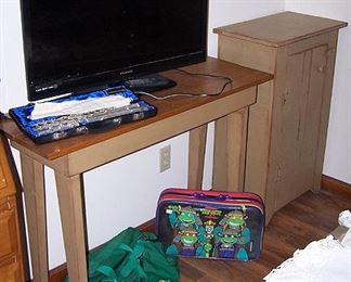 Tall pine table, TV, small painted pine cupboard, Gemeinhardt flute, Ninja turtles and Michigan Spartans bags