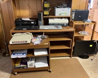 Office desk, cart on wheels in front + another cart to the right. More office items 