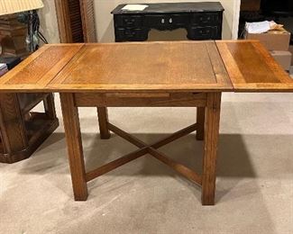 Square table with leaves that slide out from underneath to make a rectangular table. Antique.