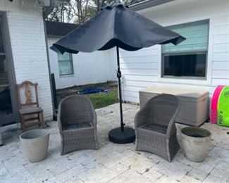 Two wicker chairs with umbrella and base