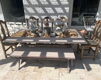 Outdoor patio table with six wooden chairs, and a bench
