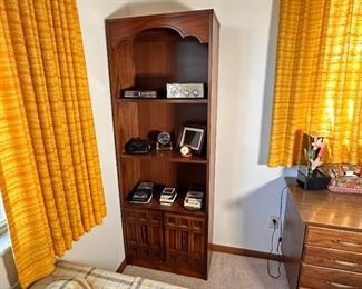 Tall wooden display/bookshelf with lower storage