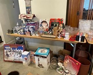 Assortment of Christmas items ranging from vhs tapes to mugs and village houses. 