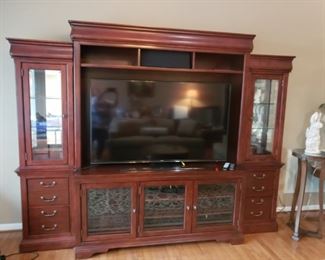 Large entertainment center w 2 lighted cases on ends. This TV is 65" samsung.