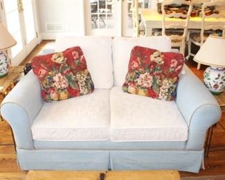 Slipcovered settee shown with nesting tables and pair of lamps.