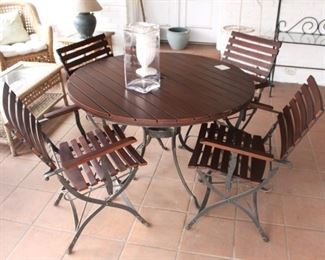 Round table with four iron based folding chairs.