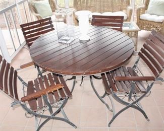 Round table with four iron based folding chairs.