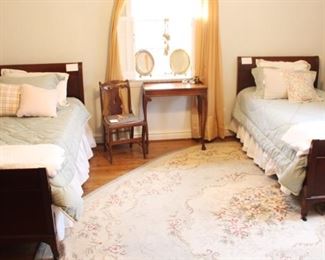 Pair of twin Mahogany beds with beautiful bedding and hooked rug.