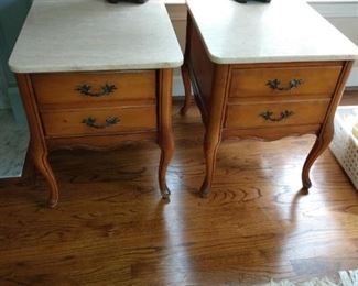 Set of two matching chair side or bedside tables with large storage drawers. Travertine top.