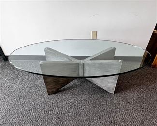 $1000 Kravet Oval Glass Top Oval Coffee Table  MTF153-13  DESCRIPTION:  Kravet's large oval cocktail/coffee table with substantial cross base in a grey painted wood with 3/4 inch oval glass top. This clean, simple look with sculptural angles beautifully complements other decor while standing out as functional art. Well made table constructed with extraordinary care. Kravet is a century old, family-owned home furnishings business known for its superb craftsmanship and attention to detail.

Dimensions: 60 x 32 x 18.5 H in.  |  3/4 in thick glass top

Condition: New.  The piece was an interior design custom order. The glass top has an internal chip incurred during shipping.  The outside suffers no cracking or chipping and is as smooth to the touch as new glass.  Glass top is easily replaceable.

Location: Local pick up Portland, OR.  Shipping suggestions available upon request. 