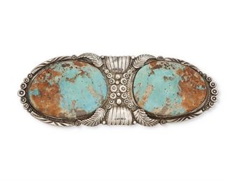 5
Mid-20th century; Dine
A Large Navajo Silver And Turquoise Belt Buckle
Stamped for unknown maker: BL [conjoined] / S
Comprised of two large slab turquoise pieces mounted to an elaborately stamped buckle with silver overlay foliate motifs
2.75" H x 7.125" W<br />224.9 grams gross
Estimate: $400 - $600